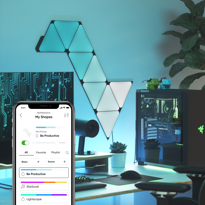 Nanoleaf Shapes Thread enabled color changing black triangle smart modular light panels mounted to a wall above a battlestation. Nanoleaf App. Similar to Philips Hue, Lifx. HomeKit, Google Assistant, Amazon Alexa, IFTTT.